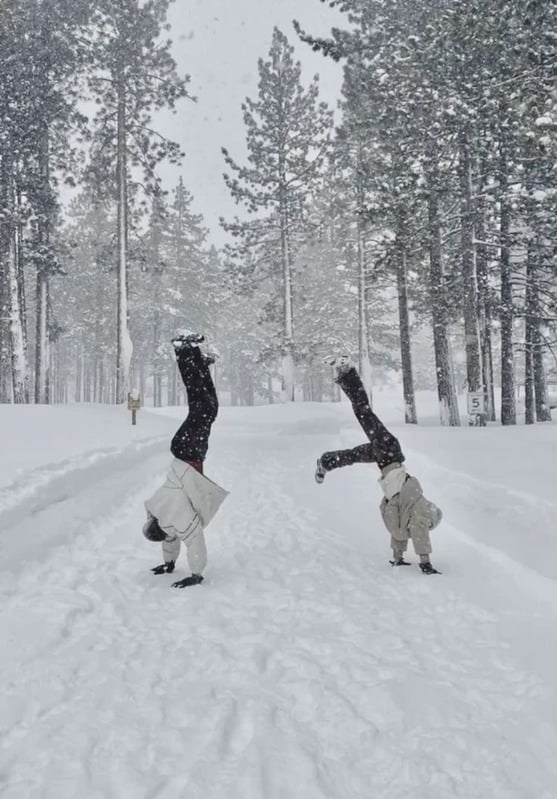 Friends doing handstands in the snow
